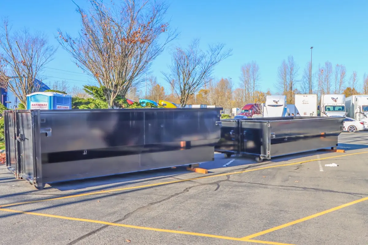 Professional dumpster rental service with roll-off container on residential driveway in Pomona